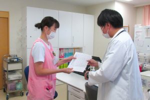医師と看護師が書類を確認している医務室での業務風景